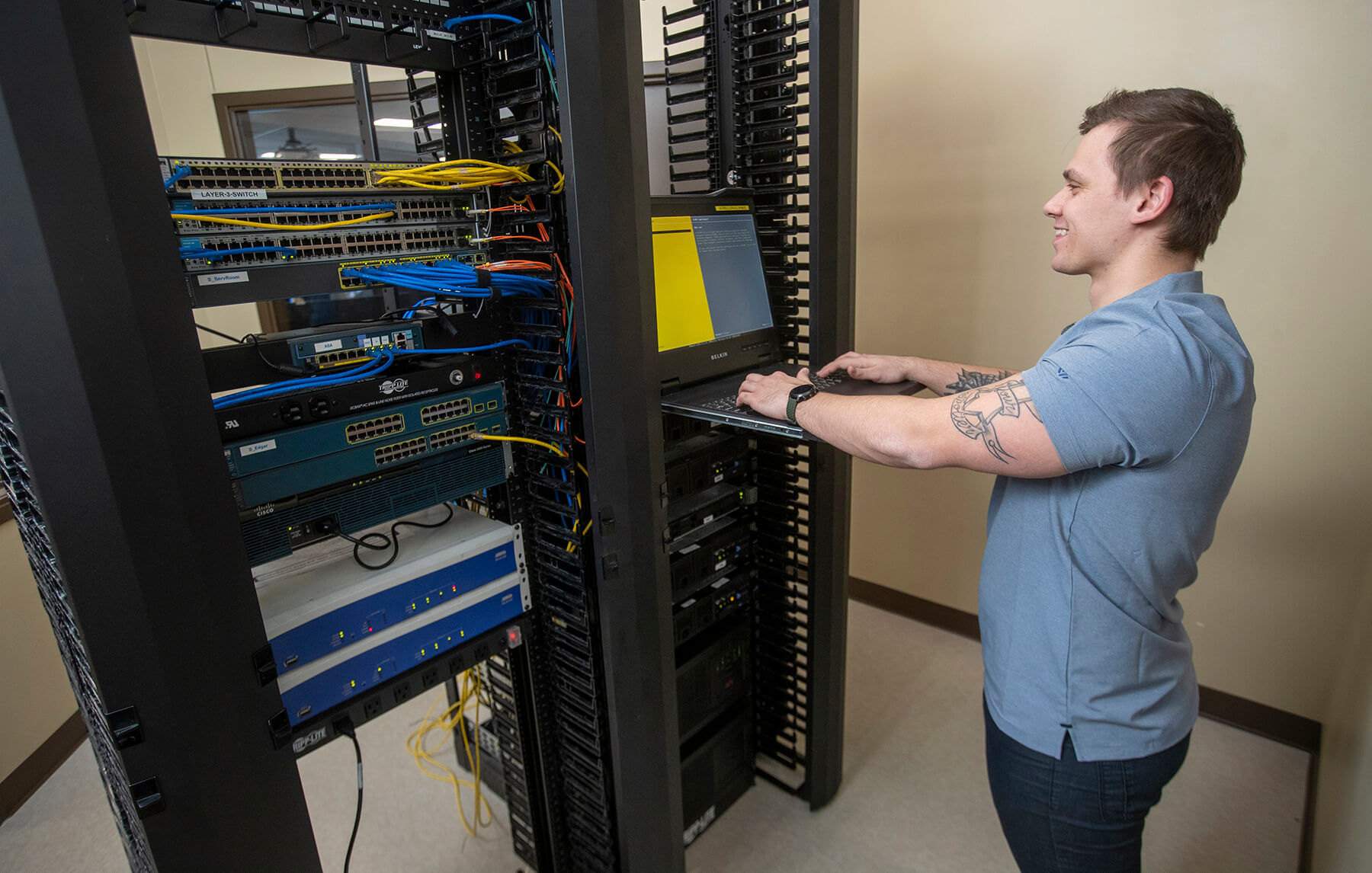 An IT - Cybersecurity Specialist student working hands-on with classroom technology
