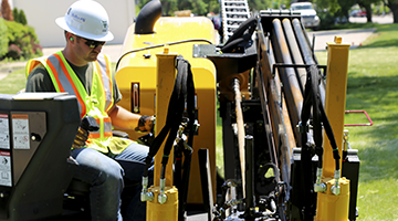 A utility construction student using a heavy machine
