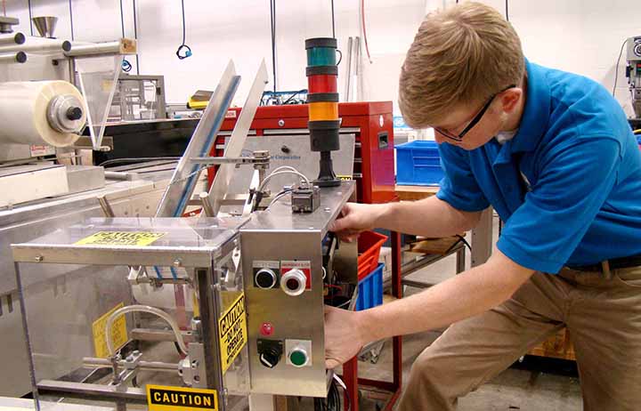 Student working with equipment in the automated packaging lab