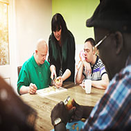 Nurse with down syndrome patients at disability care home having fruit for nutrition and vitamins