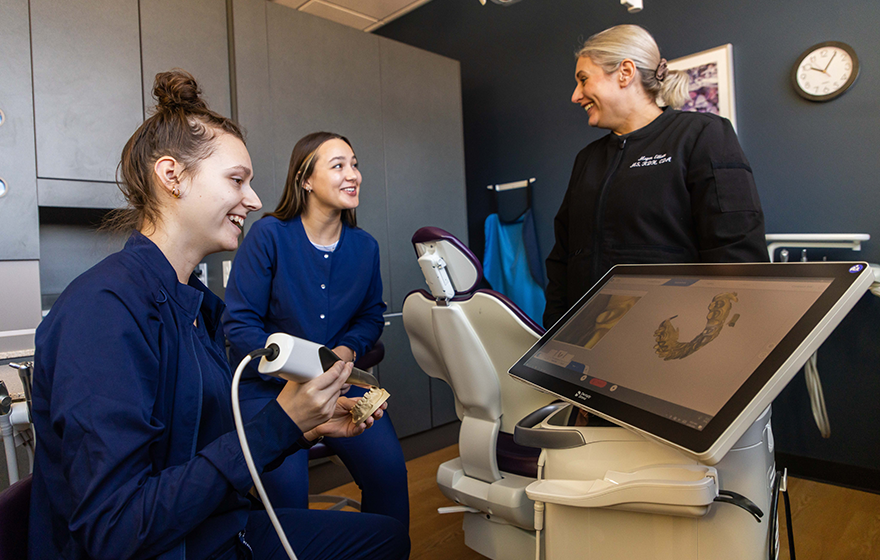 Instructor teaching students how to use a dental tool