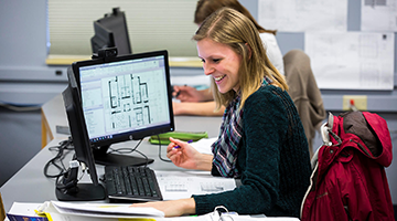 A student looking at blueprints on a computer