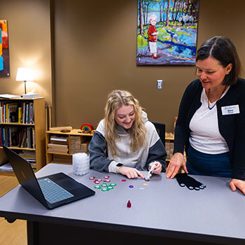 Instructor showing a student a project to teach children
