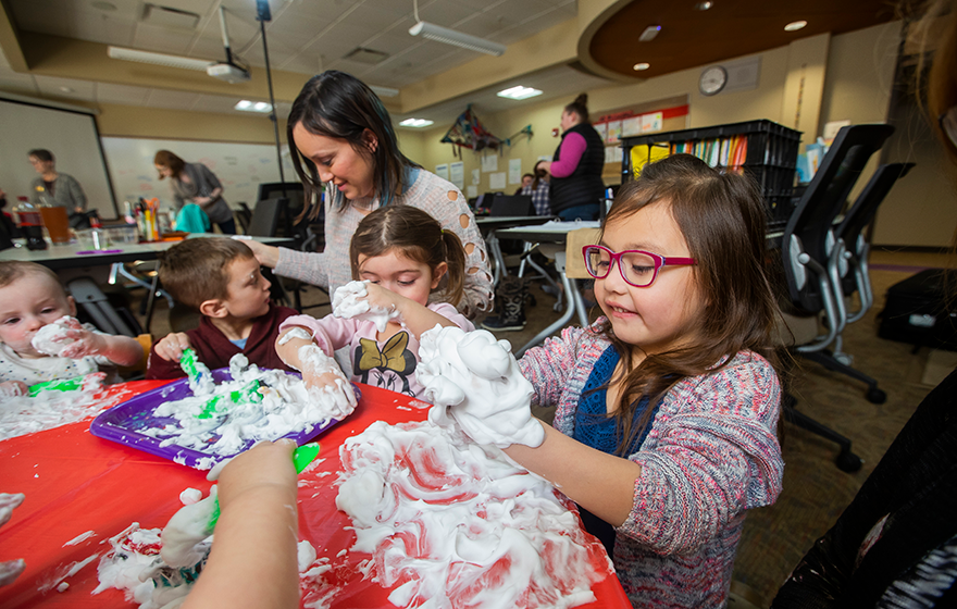 Kids playing with shaving cream in the classroom