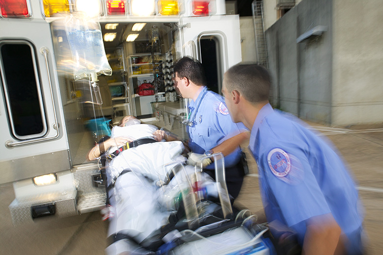Emergency Medical Services Paramedics load a patient into the back of an ambulance