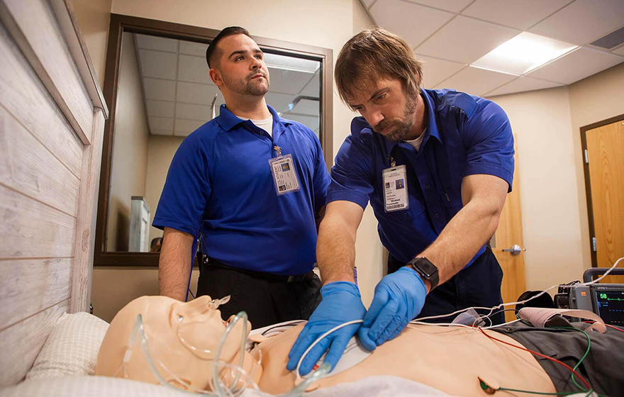 EMT-Paramedic students practicing skills on a simulated patient