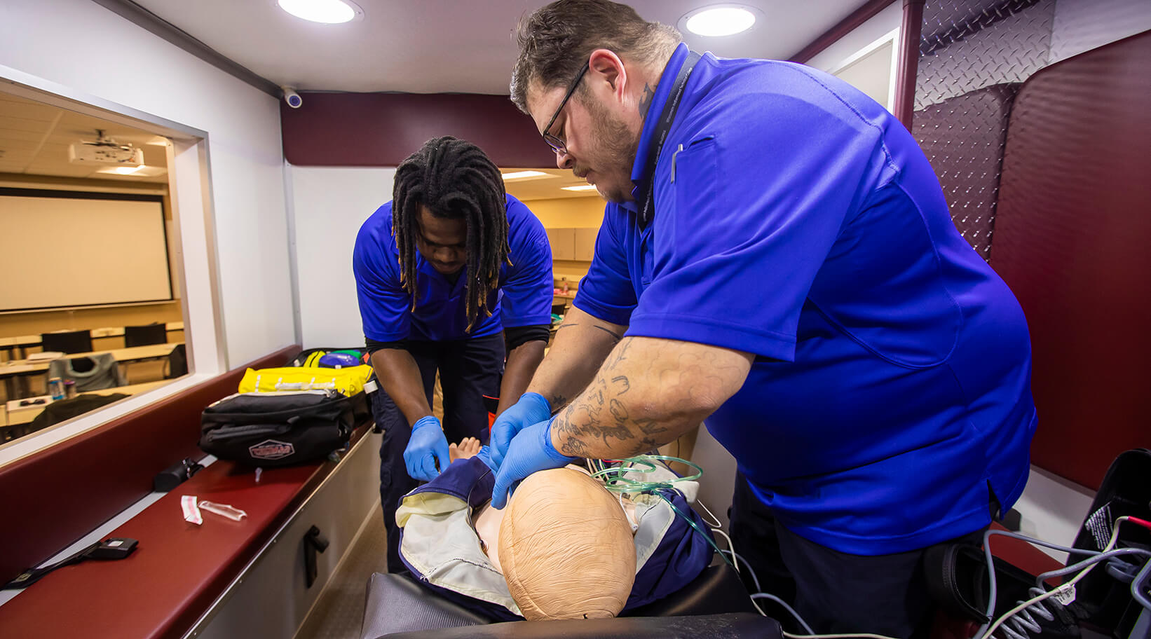 EMT students doing hands-on work with a simulated person