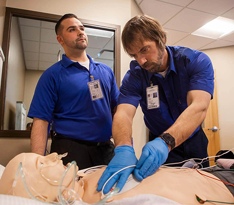 EMT-Paramedic students practicing skills on a simulated patient