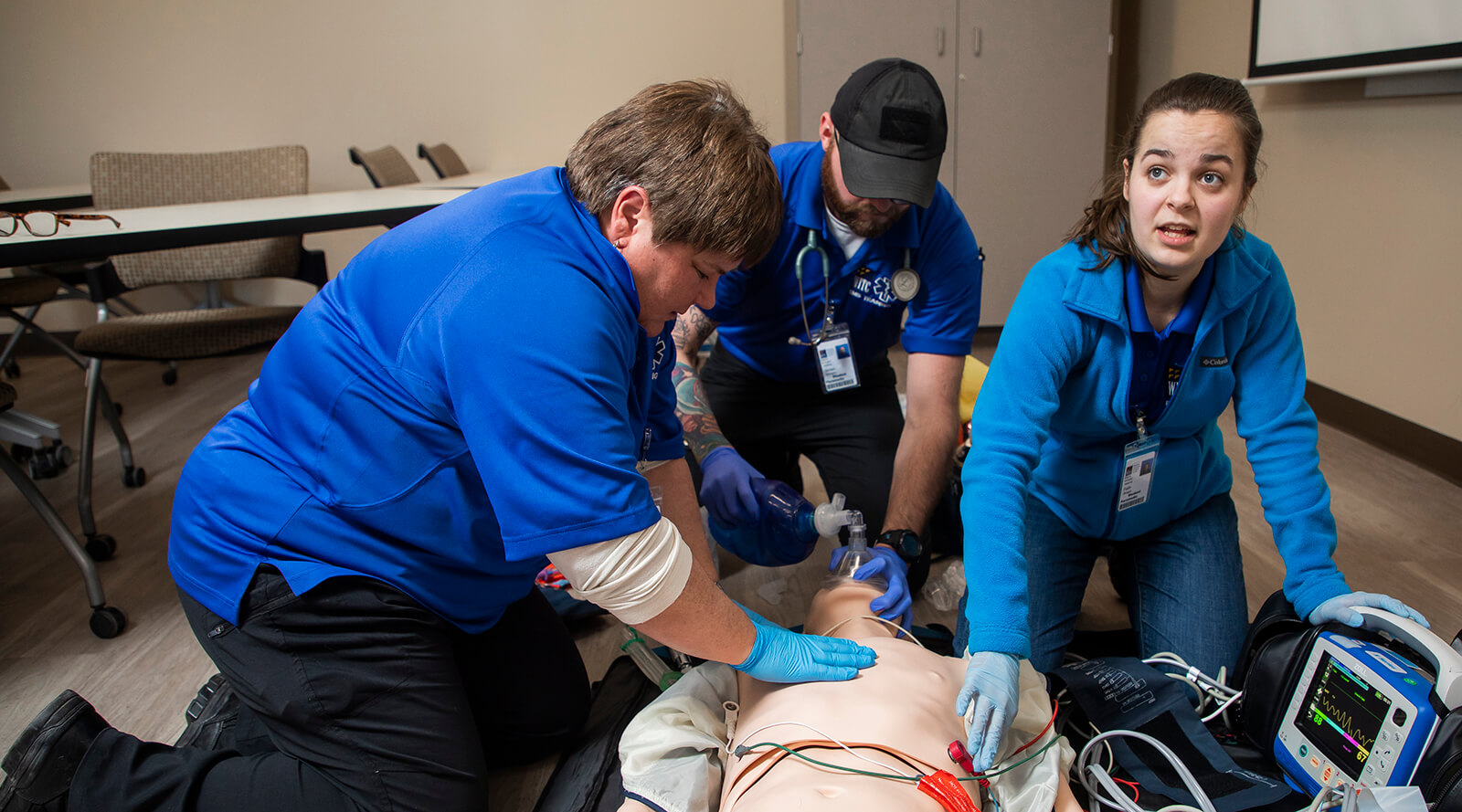 A group of EMT students practicing skills on a simulated patient