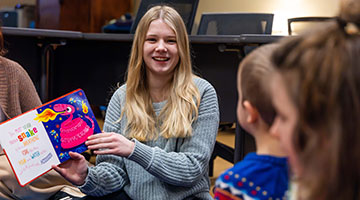 Student reading to children in the classroom