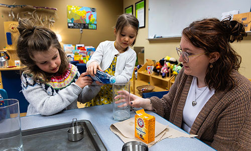 Early Childhood Education student laughing and playing with two children