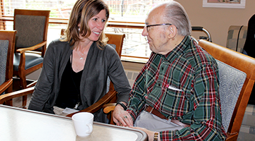 Director of an assisted living facility talking with a resident 