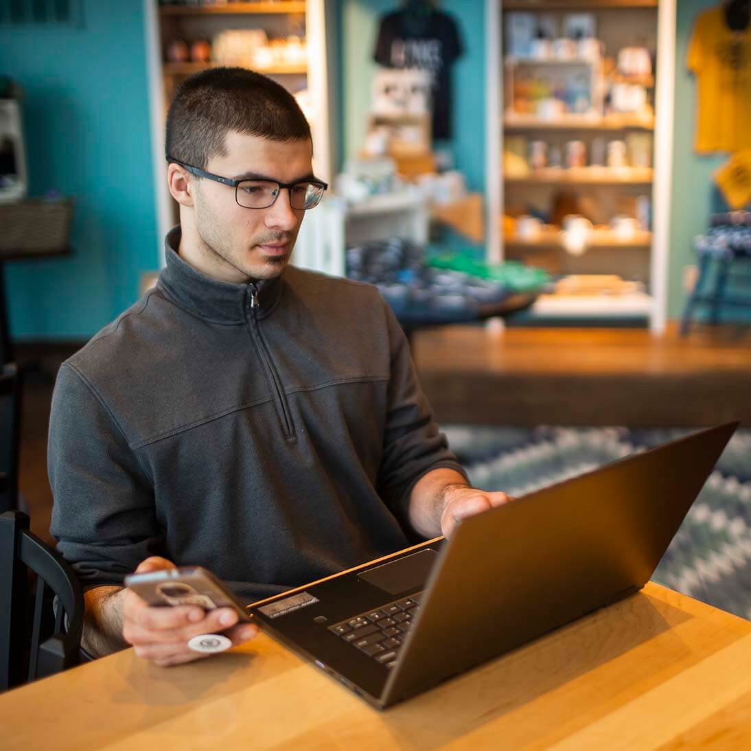 A student sitting in a cafe and working on classes