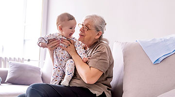 Grandmother holding grandchild on the couch