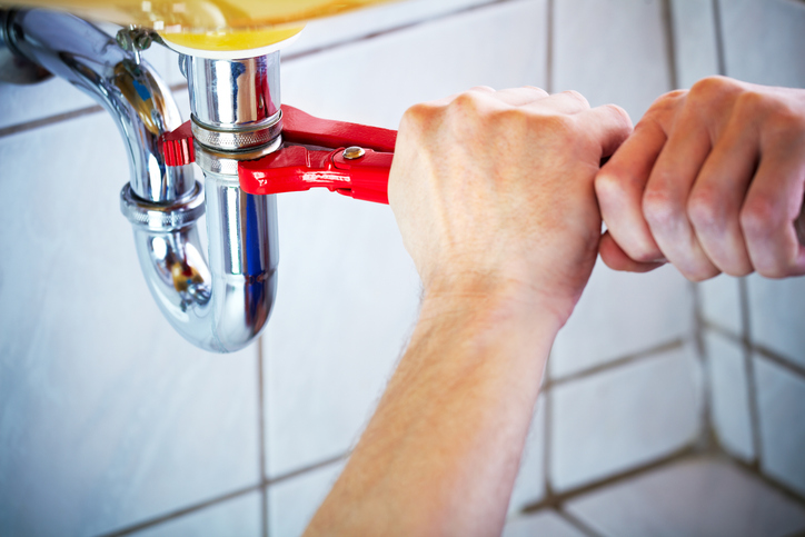 Plumber hands fixing a faucet