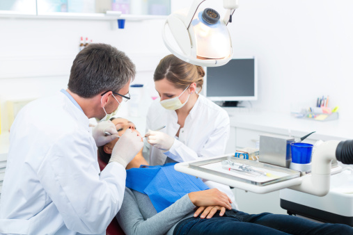 Patient with dentist and dental assistant