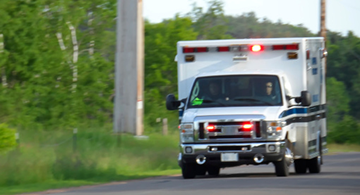 A rushing ambulance driving down a country road