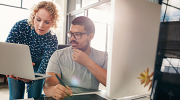 Two business professionals looking at a laptop