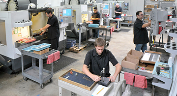 CNC machinists working in a shop