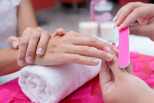 Nail Technician filing a client's nails