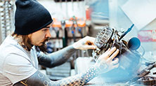 A power sports technician repairing a motorcycle engine