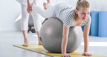 A child during pediatric occupational therapy on an exercise ball