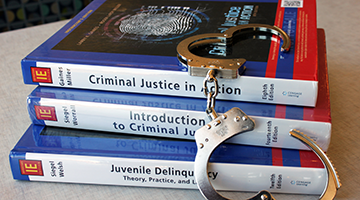 Criminal justice textbooks with handcuffs