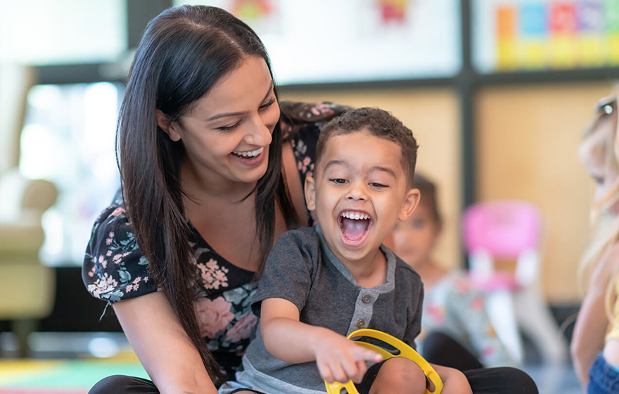 A child care worker playing with a preschool-aged kid