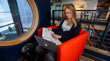 A student sitting in a cafe and working on classes