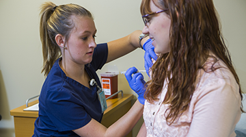 Students practicing skills on a patient