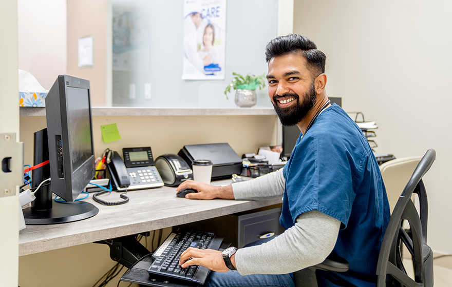 A medical office professional at his desk