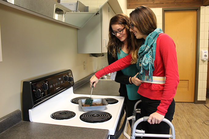 Students learning how to assist someone in the kitchen