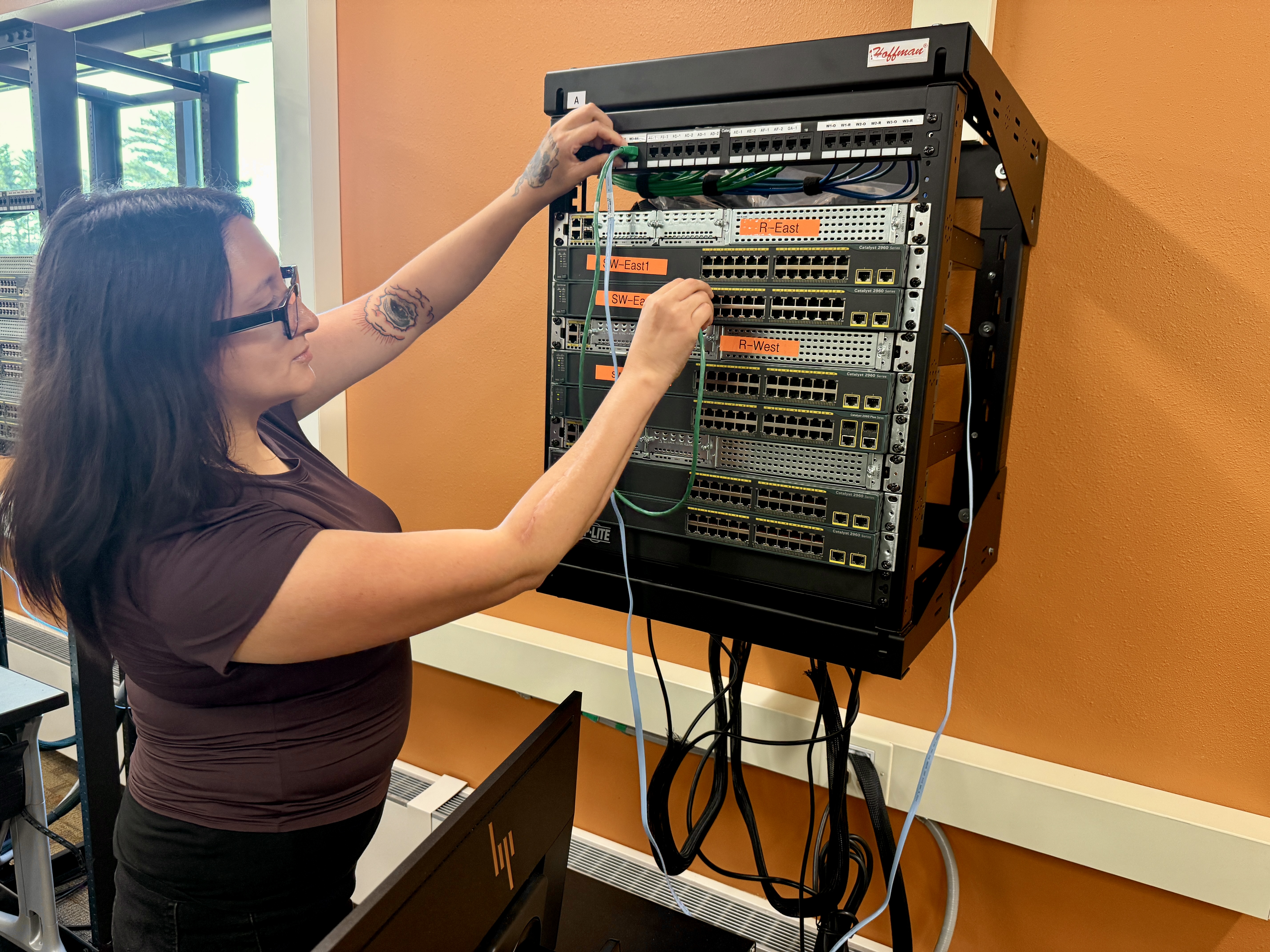 Sierra Franzel connects network cables in a cybersecurity lab at Northwood Technical College’s Ashland campus.