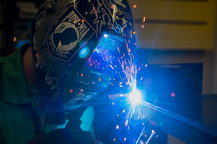 A student welding and sparks flying