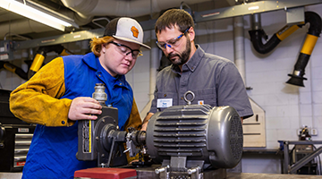 Instructor showing student maintenance on machine