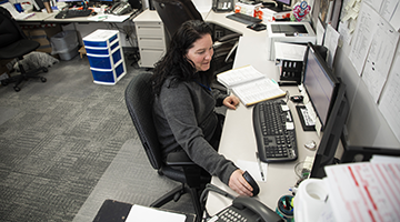 A medical administrative professional sitting at a desk in an office