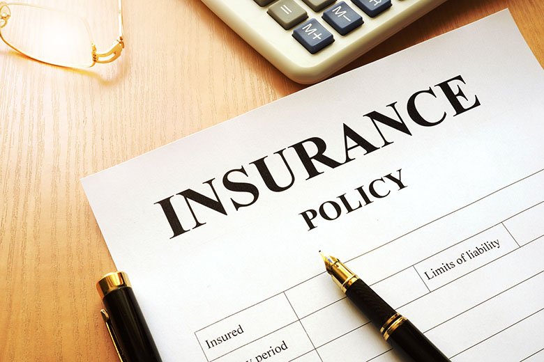 Insurance Continuing Education Paper titled Insurance Policy on a table with pen, calculator and eyeglasses nearby