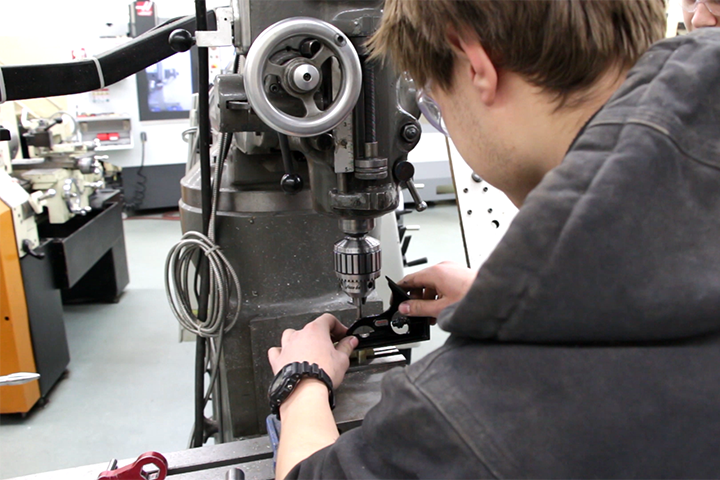 A machine tool operation student doing hands-on work