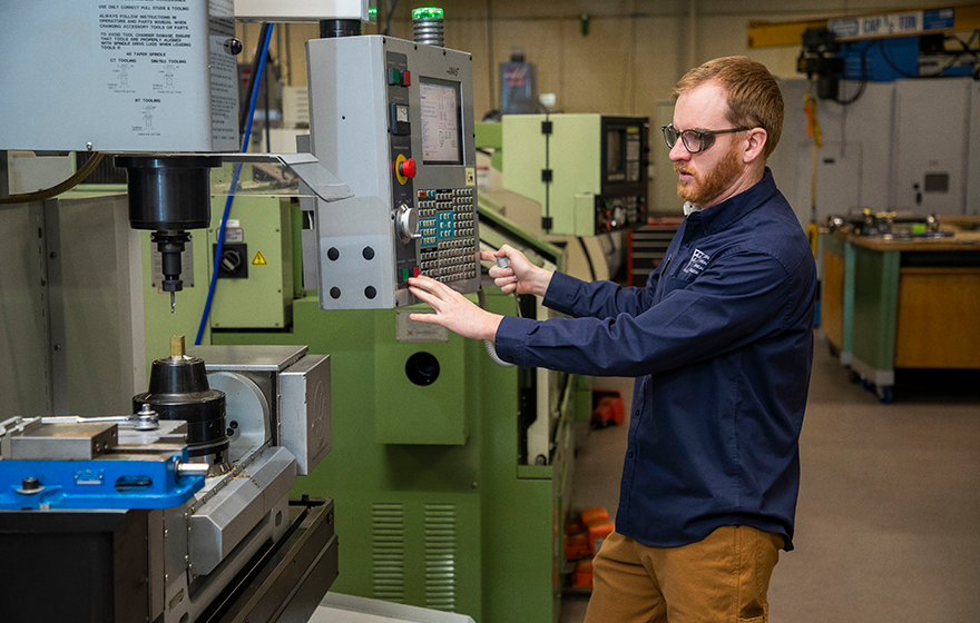 A machine tool student using a CNC machine