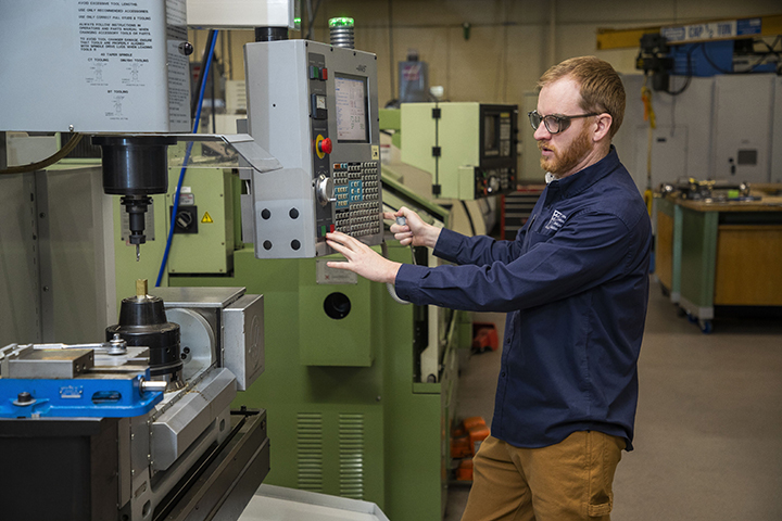 A machine tool student using a CNC machine