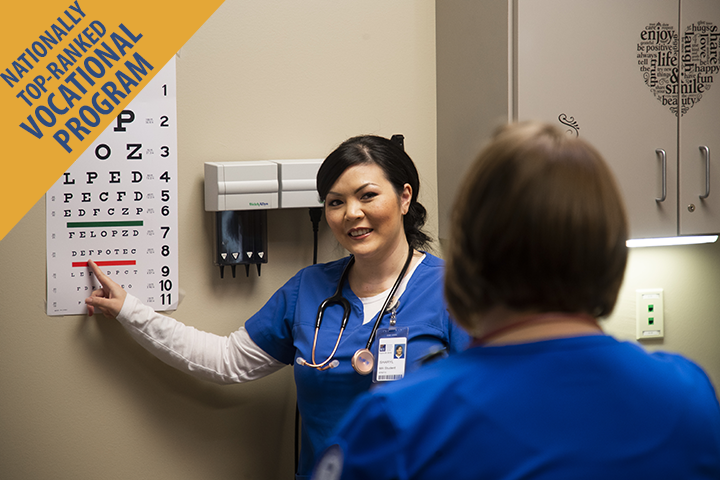 Nationally top-ranked vocational program. A medical assistant student doing an eye exam on a student patient