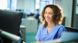 A medical office professional on the phone at the front desk