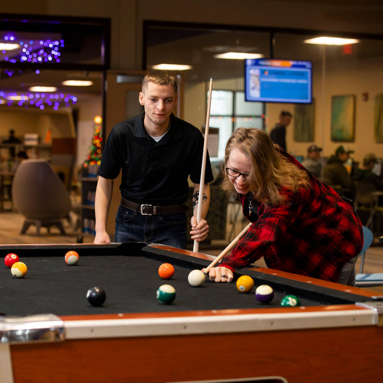 Two students playing pool on campus