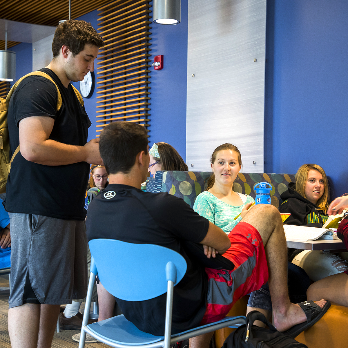 Group of students hanging out at a table in commons area