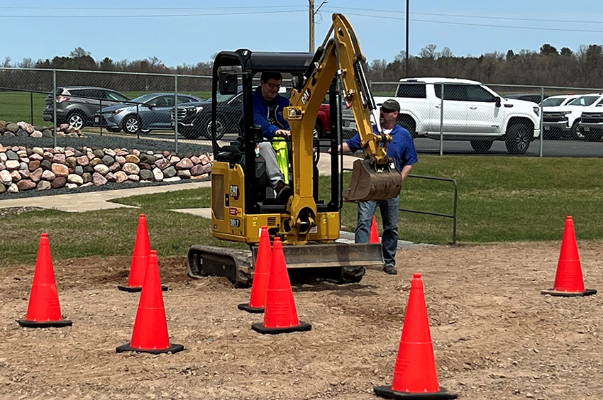 Student running a backhoe