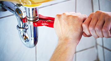 Plumber hands fixing a faucet