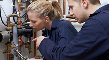 A plumbing student working on the job