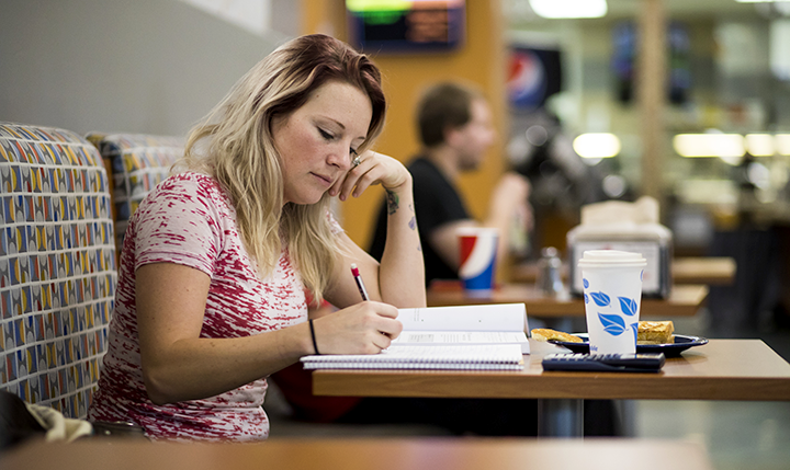 Student studying at a table in The Hub Student studying at a table in The Hub