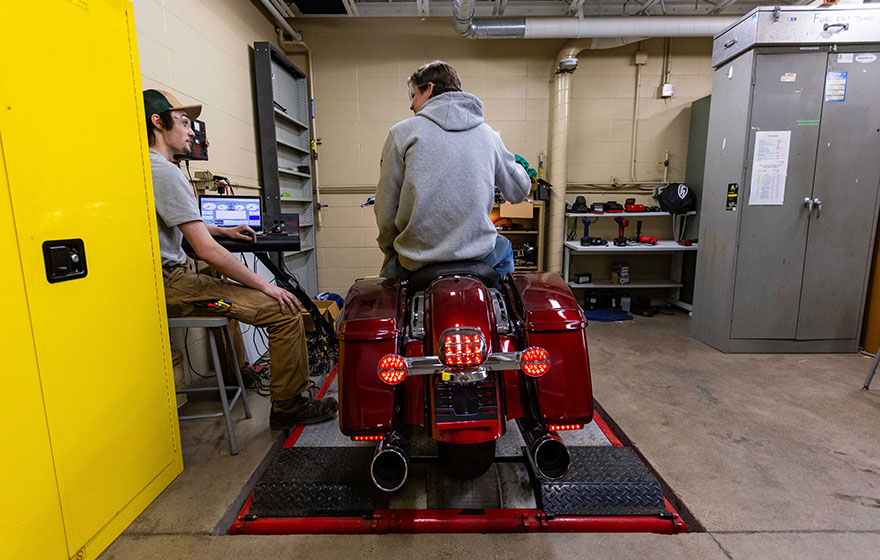 A student sitting on a motorcycle