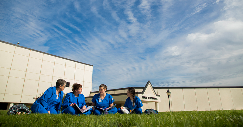 Superior Campus main entrance and students studying on in the sunshine